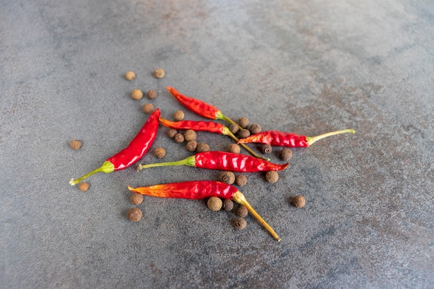 Hot peppers with spices on wooden table close up