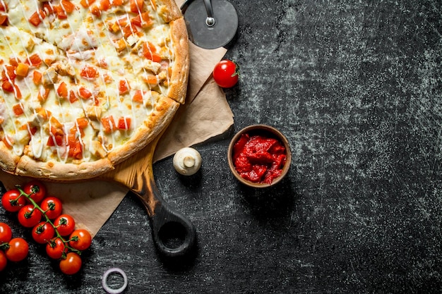 Hot pizza on paper with cherry tomatoes