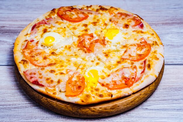 Pizza calda servita sul vecchio tavolo deliziosa pizza servita su un piatto di legno