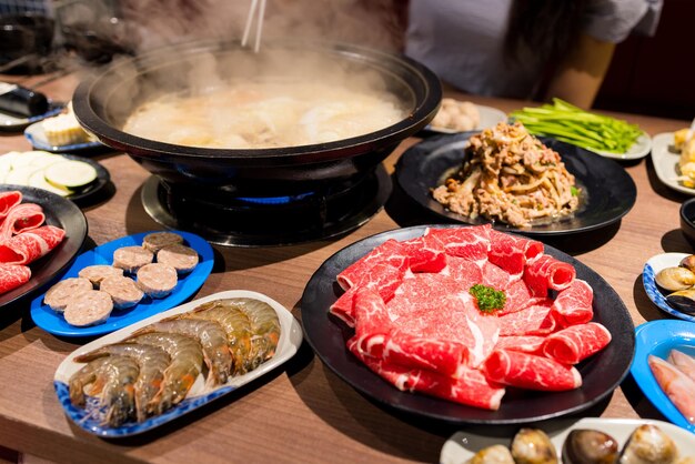 Photo hot pot with lots of food on the table