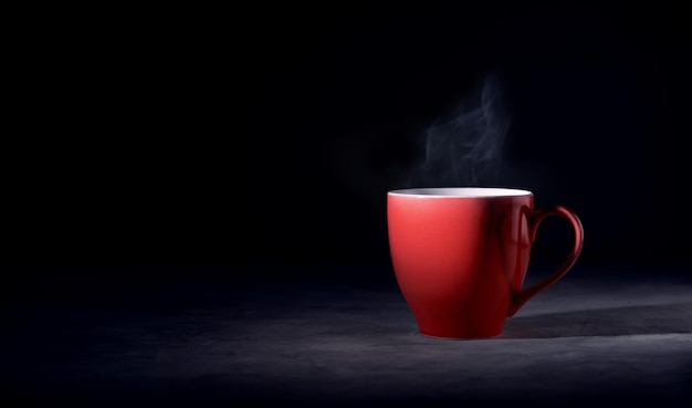 Hot red coffee cup op tafel met stream dark tone zijaanzicht met meer kopieerruimte