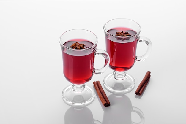 Hot red mulled wine isolated on white background with christmas spices and shortcakes