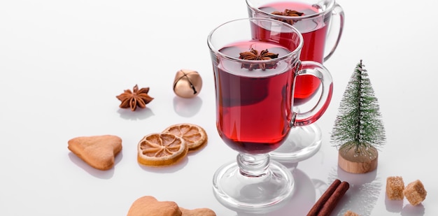 Hot red mulled wine isolated on white background with christmas spices and shortcakes