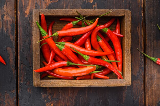 Hot Red thai pepper set, in wooden box, on old dark  wooden table, top view flat lay