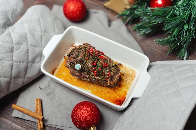 Hot roasted beef dish for Christmas dinner Festive Christmas main menu Hands in potholders hold roasted beef