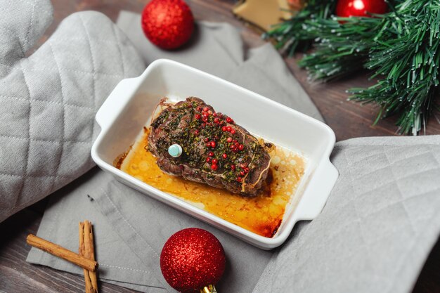 Фото Горячее жареное говядино на рождественский ужин праздничное рождественское основное меню руки в горшках держат жареную говядину