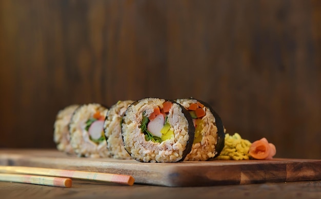 Hot roll set sashimi japanese food on wooden background with lemon and chopsticks