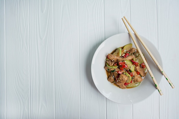 Hot salad with chicken, zucchini and chili, sesame seeds and herbs.