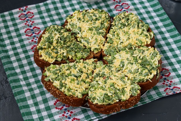 Photo hot sandwiches with wild garlic, green onions, eggs, cheese and parsley