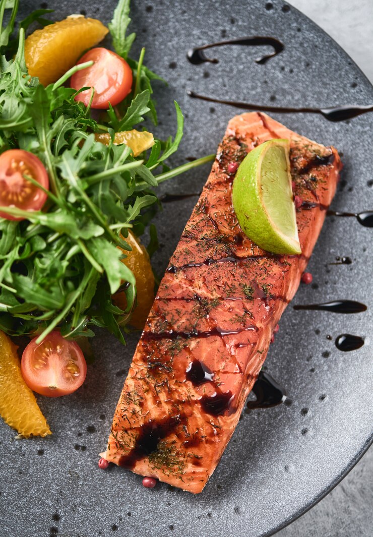 Photo hot smoked salmon with arugula salad, cherry tomato and orange. healthy eating.