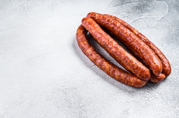 Hot Smoked sausages on a rustic table. White background. Top view. Copy space.