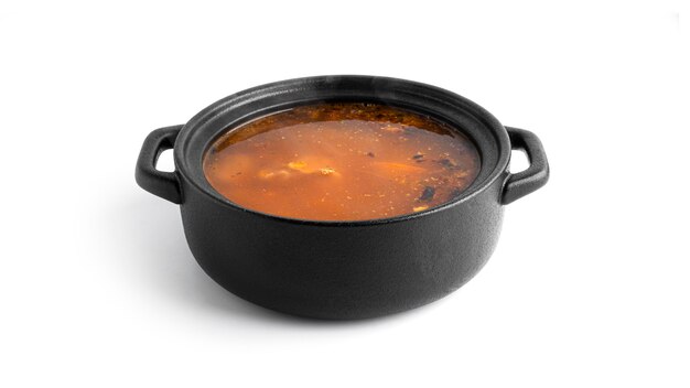 Hot soup in a black pot isolated on a white surface