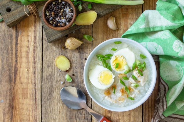 Hot soup chicken with ginger rice and garlic in a bowl on a rustic table Top view flat lay