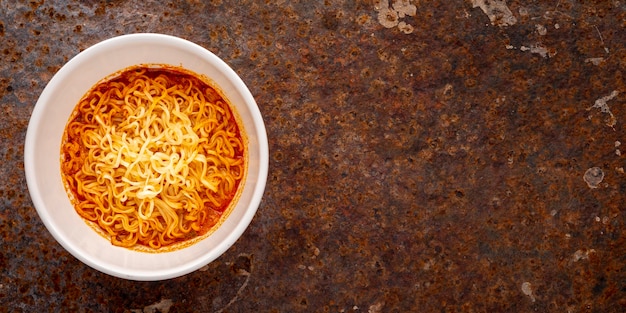 Hot and sour noodle soup, Tom Yum shrimp flavor in white ceramic bowl on rusty texture background with copy space for text, Tom Yum Goong, Tom Yum Kung, Thai food