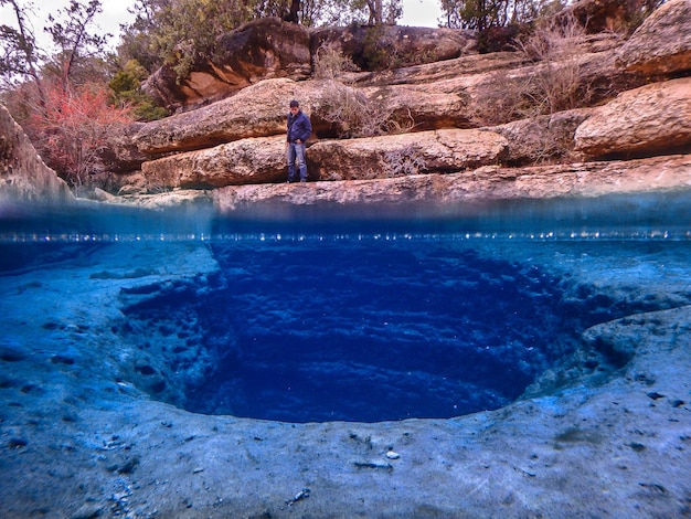 Hot spring against man standing on rock