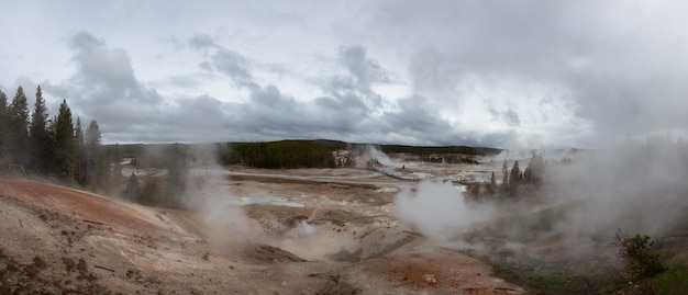 Фото Гейзер горячего источника с красочной водой в американском ландшафте