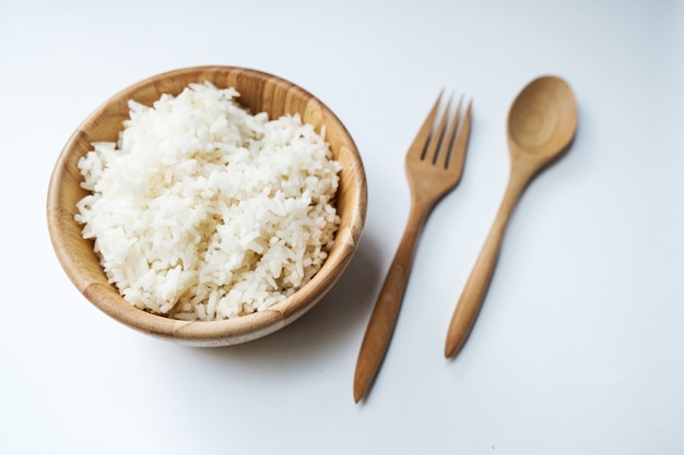 Горячий разогретый рис в деревянной миске на белом фоне изолированный