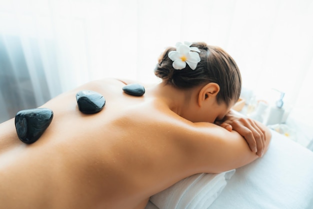 Photo hot stone massage at spa salon in luxury resort quiescent