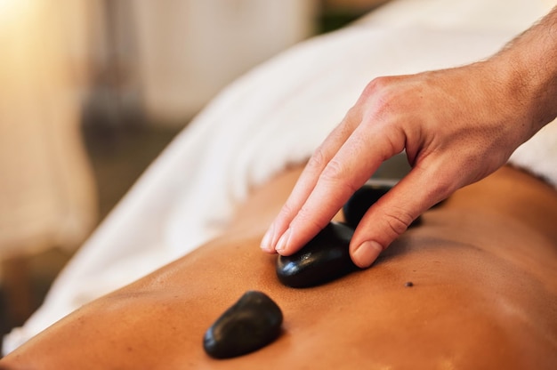 Hot stone massage spa and skincare for wellness health and physical therapy to relax in luxury Mind body and spirit wellness with rock therapy on skin in closeup with oil zen or natural cosmetic