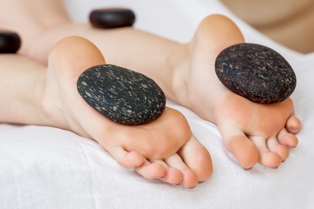 Photo hot stones lying on female feet