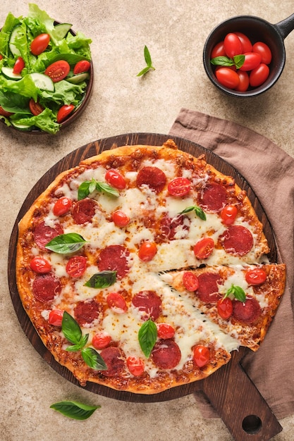 Foto pizza tradizionale italiana piccante e gustosa con pepperoni, formaggio, pomodori e verdure, vista dall'alto