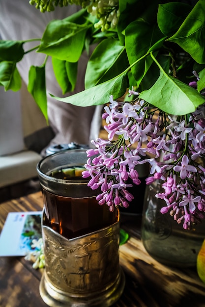 Hot tea and a bouquet of lilacs