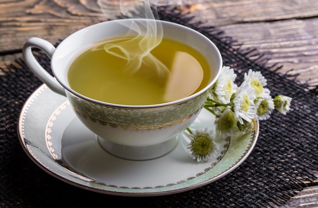 Tè caldo in una tazza su un vecchio tavolo.