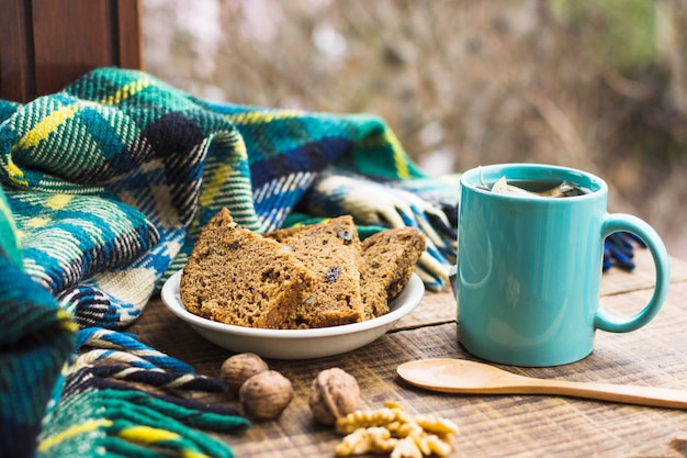 Foto tè caldo e spuntino sul tavolo vicino coperta