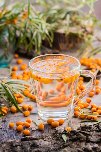 Hot tea with berries of sea-buckthorn in a glass