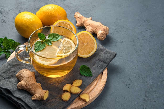 Hot tea with lemon and ginger on a graphite background