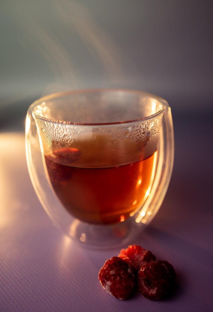 グラスにラズベリーを入れた熱いお茶