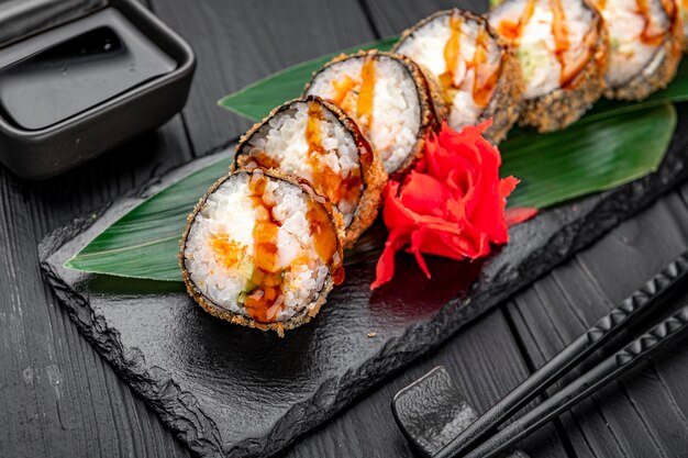 Hot tempura roll with salmon and cheese Traditional delicious fresh sushi roll set on a black background