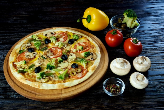 Superficie di legno scuro della pizza vegetariana calda.
