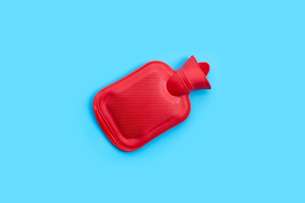 Hot water bag on blue wall. Copy space