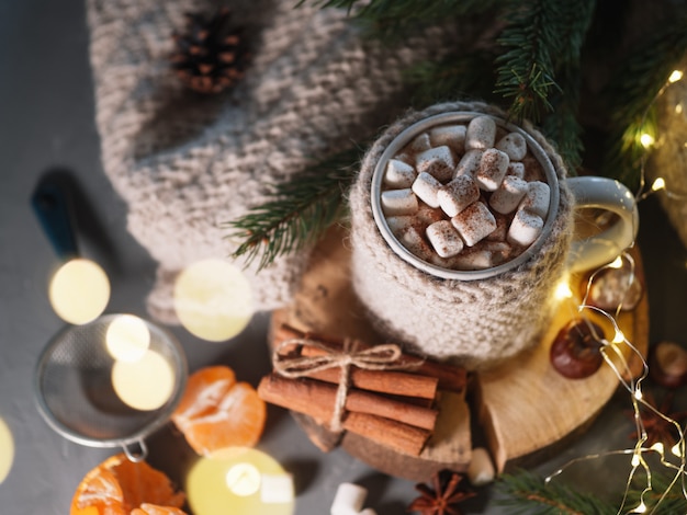 写真 熱い冬のドリンクチョコレート、ココア、シナモンとニットマグカップのテーブルの上にマシュマロとコーヒー