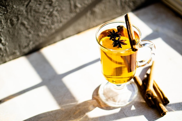 Hot winter drink with cinnamon and lemon on bright sunny day