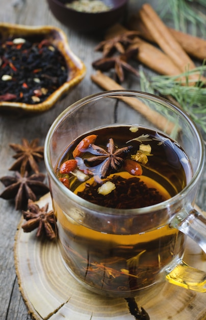 Hot winter tea with spices on wooden table