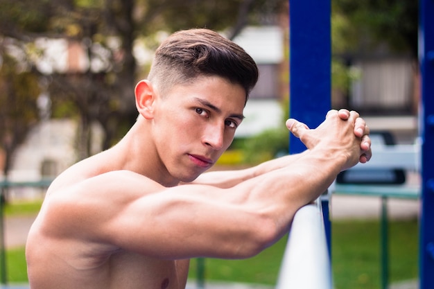 Hot young muscular man working out in a playground