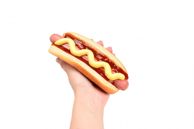 Hotdog in vrouwenhand op witte achtergrond wordt geïsoleerd die. Kopieer ruimte.