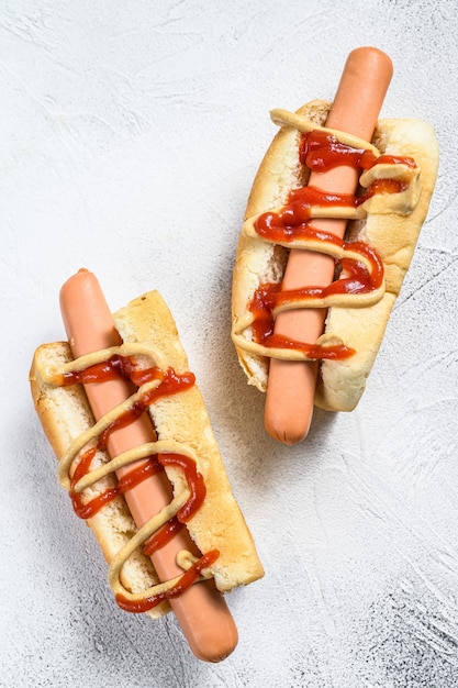 Hotdog met gele mosterd en rode ketchup. Witte achtergrond. Bovenaanzicht.