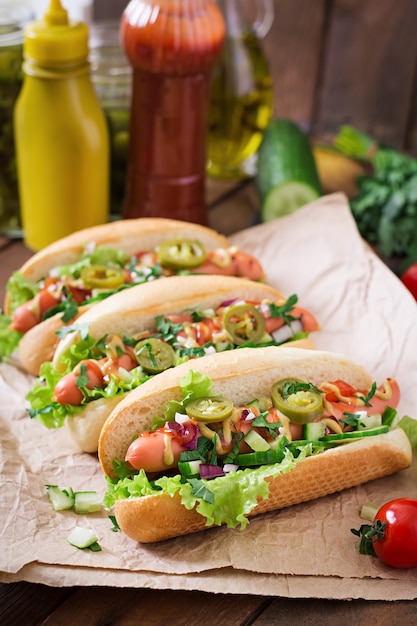 Hotdog met jalapenopeper, tomaat, komkommer en sla op houten oppervlak