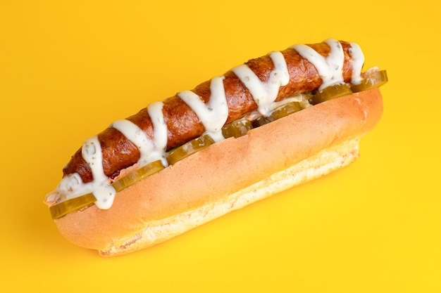 Hotdog met kippenhotdog op gele lichte achtergrond als achtergrond