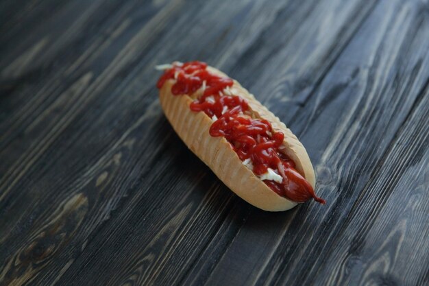 Foto hotdog met pikante saus op donkere achtergrondfoto met kopieerruimte