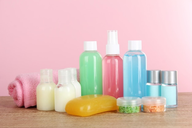 Hotel amenities kit on table on pink background