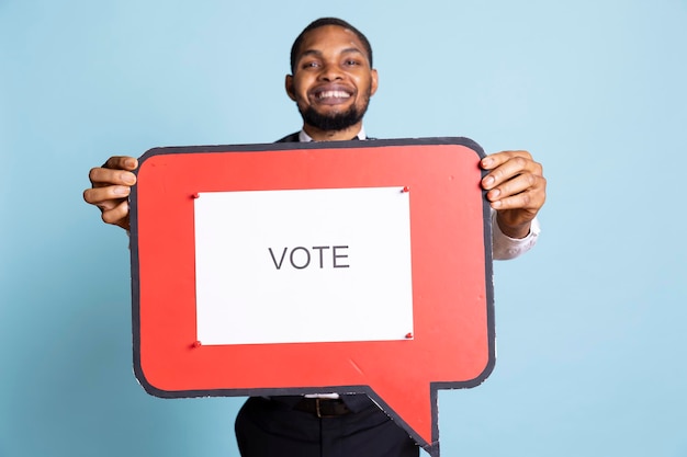 Hotel concierge holding a speech bubble with the message to vote