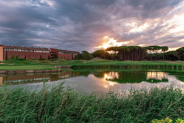 Hotel en golfbaan bij zonsondergang aan het meer