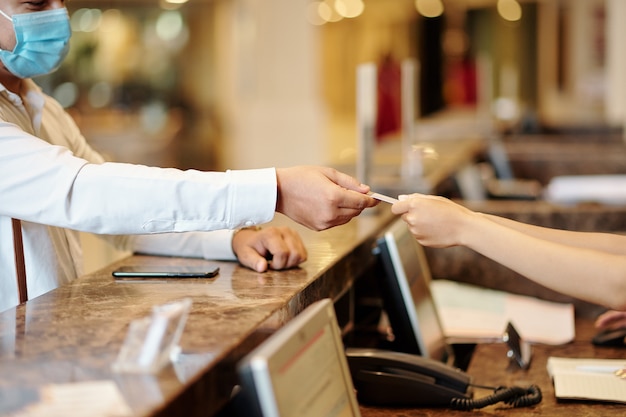 Hotel guest giving credit card to receptionist to pay for room service