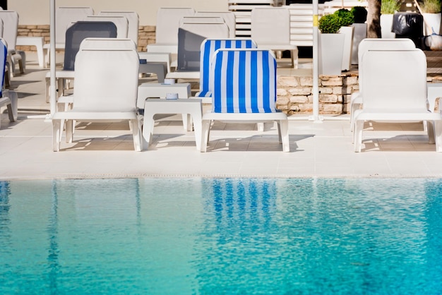 Hotel Poolside Chairs near a swimming pool. Summer shot