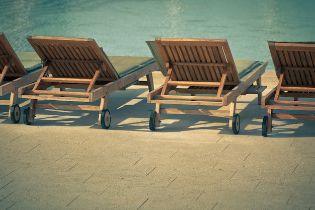 Sedie a bordo piscina dell'hotel con vista sulla piscina. scatto orizzontale in stile vintage