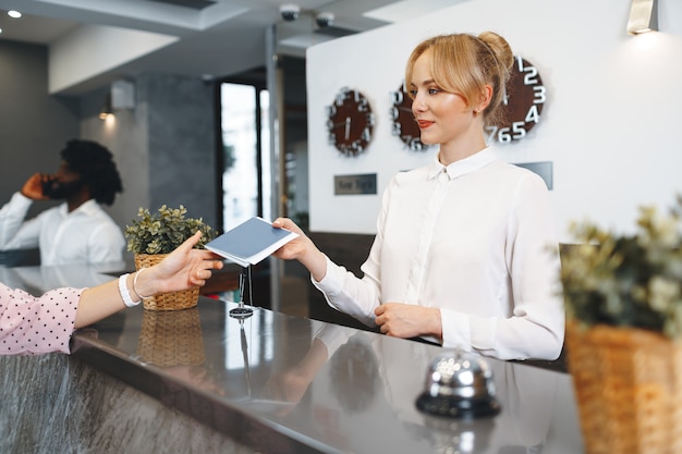 Hotel receptionist woman takes guest's passport for check